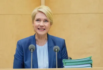 Manuela Schwesig redet an einem Podium mit zwei Mikrofonen.