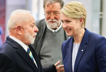 Lula links spricht mit Manuela Schwesig rechts. Im Hintergrund ein Mann mit Bart.