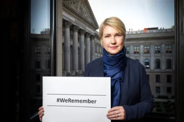 Manuela Schwesig hält ein weißes Schild mit der Aufschrift #erremember.